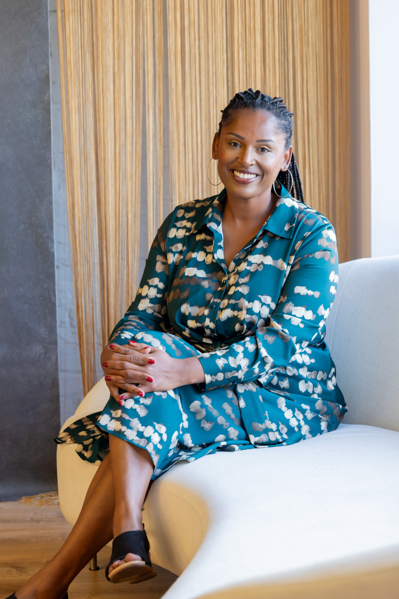 Dr. Paris Woods seated on a curved sofa